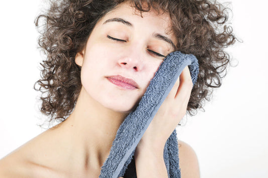Femme essuyant délicatement son visage après application d'un savon pour peau atopique
