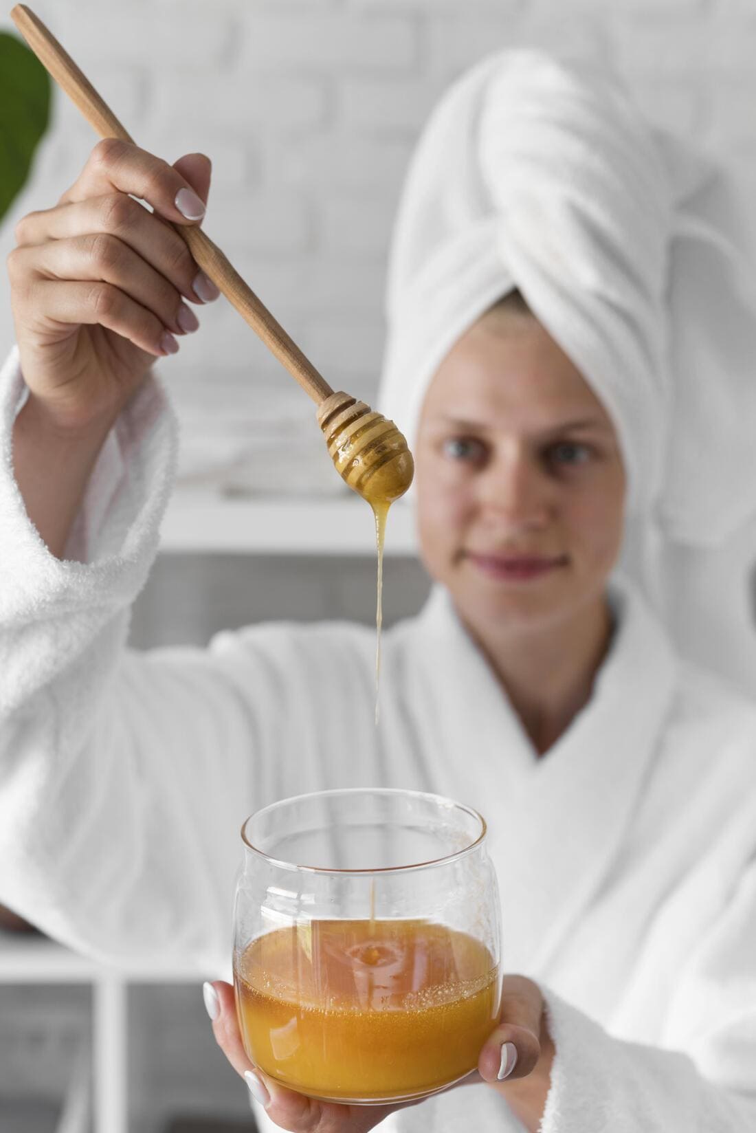 Une femme qui prépare un baume au miel pour le visage